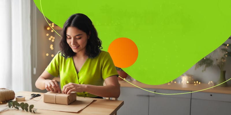 Persona envolviendo regalos navideños hechos a mano para ahorrar dinero en Navidad.