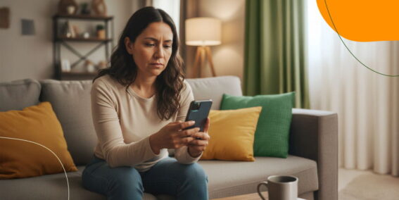 Persona con ansiedad financiera revisando su dinero en el celular en casa