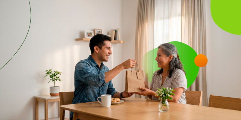 Hombre entregando flores a su mamá como regalo práctico para el Día de las Madres