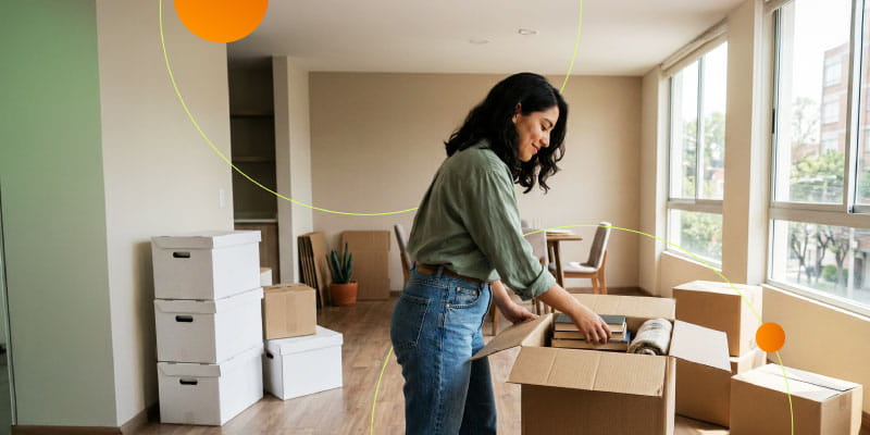 Mujer revisando su nuevo departamento mientras organiza cajas durante una mudanza